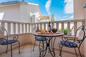 - une table et des chaises sur un balcon avec une bouteille de vin dans l'établissement Villa Lux, à Promajna