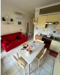 a living room with a white table and a red couch at Gardalakeapartment a Sirmione in Sirmione