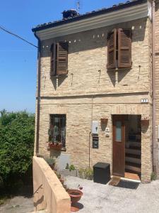 un edificio de ladrillo con persianas marrones. en CIRIBACCO ROOMS, en Macerata