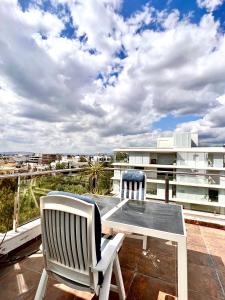 d'une terrasse avec 2 chaises et une table sur un balcon. dans l'établissement CityCenter Penthouse mini Private Pool with Hydromassage and Great Town View, à Athènes