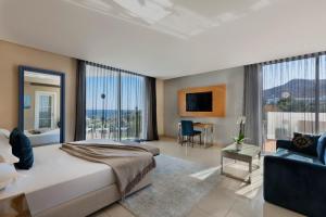 a bedroom with a large bed and a living room at Herbert Samuel The Reef Eilat in Eilat