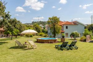 a yard with chairs and a pool and a house at Casa do Lamaçal - Minho's Guest in Guardizela