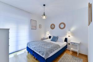 ein weißes Schlafzimmer mit einem Bett und einem Tisch in der Unterkunft CROWONDER Adriatic Premium Villa Vodice near the Beach in Vodice