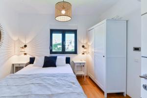 ein weißes Schlafzimmer mit einem Bett und zwei Nachttischen in der Unterkunft CROWONDER Adriatic Premium Villa Vodice near the Beach in Vodice