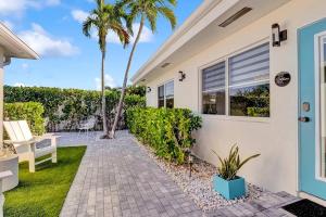 una casa blanca con palmeras y un camino en Oceana @ Casa Del Sol en Fort Lauderdale