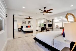 Habitación blanca con cama y espejo en Oceana @ Casa Del Sol en Fort Lauderdale