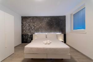 ein Schlafzimmer mit einem Bett mit zwei Handtüchern darauf in der Unterkunft CityU Grazioli 27 Appartamento Trento Città - 2 stanze con doppio parcheggio privato in Trient