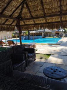 a resort with a swimming pool and a straw umbrella at CUMBUCO - Eco Paradise - AP 112 in Caucaia