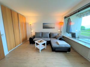 uma sala de estar com um sofá e uma mesa em Ferienpark Sierksdorf App 561 - Strandlage em Sierksdorf