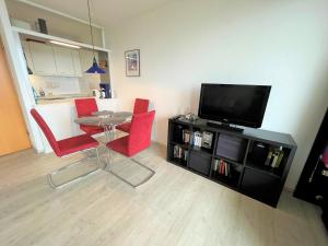 een woonkamer met een tafel en rode stoelen bij Ferienpark Sierksdorf App 495 - Strandlage in Sierksdorf
