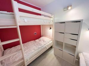1 dormitorio con 2 literas y armario en Ferienpark Sierksdorf App 495 - Strandlage, en Sierksdorf