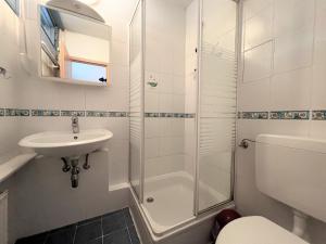 een badkamer met een douche, een wastafel en een toilet bij Ferienpark Sierksdorf App 495 - Strandlage in Sierksdorf