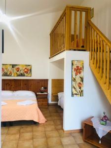 1 dormitorio con 1 cama y escalera de madera en Agriturismo Valle di Chiaramonte, en Chiaramonte Gulfi