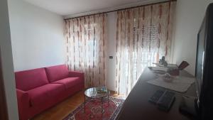 uma sala de estar com um sofá rosa e uma mesa em B&V Mountain Dream Home em Aosta