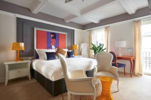a bedroom with a large bed with a painting on the wall at Aria Hotel Budapest by Library Hotel Collection in Budapest