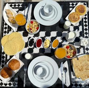 a table with plates of food on a checkered table cloth at Les Jardins de Kesali in Marrakesh