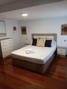 a bedroom with a large bed with white sheets at Duplex Las Piraguas in Arriondas