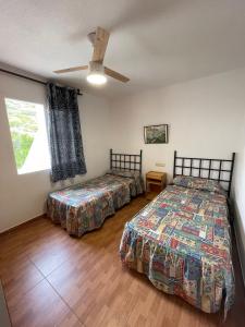 1 dormitorio con 2 camas y ventilador de techo en Alpen1 Font Nova, en Peñíscola