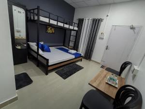 ein kleines Zimmer mit einem Etagenbett und einem Tisch in der Unterkunft The Corner Inn (Lodge) in Guwahati