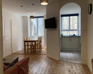 a living room with a kitchen and a table with chairs at Apartment Centre Historic in Marvejols