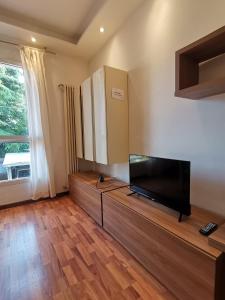 un soggiorno con TV a schermo piatto su un pavimento in legno di Orio Home a Bergamo
