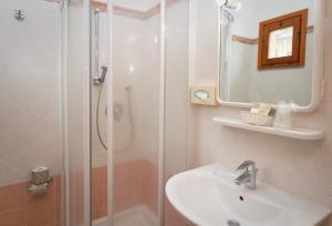 a bathroom with a shower and a sink and a mirror at Hotel Anna in Fetovaia