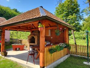 un gazebo in legno con una griglia in un cortile di STD Gavrilović a Bajina Bašta