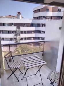 balkon z 2 krzesłami i stołem oraz budynek w obiekcie Résidence Graziella Appartement 510 w mieście Juan-les-Pins