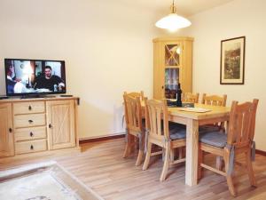 a dining room with a table and a flat screen tv at Ferienwohnung Harms in Garlstorf