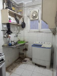 uma cozinha suja com um caixote do lixo em Manial El roda no Cairo