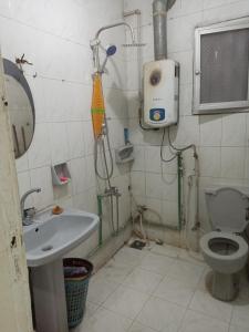 uma casa de banho com um chuveiro, um WC e um lavatório. em Manial El roda no Cairo