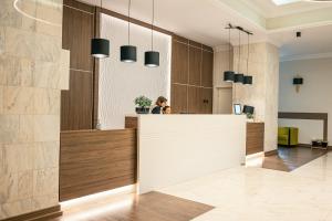 a lobby with a reception counter and a woman at Hotel Trotuş in Onești