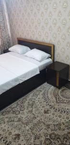 een slaapkamer met 2 bedden en een tafel bij Кв суточная in Simkent