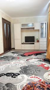 een woonkamer met een groot tapijt op de vloer bij Кв суточная in Simkent