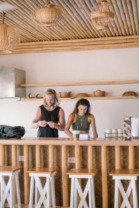 zwei Frauen, die hinter einem Tresen in einem Raum stehen in der Unterkunft Happiness Hostel Siargao in General Luna