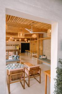 d'un salon avec des chaises, des tables et un plafond dans l'établissement Happiness Hostel Siargao, à General Luna
