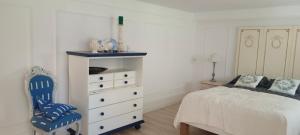 a bedroom with a bed and a dresser and a chair at Apartament WILLA ANTA in Dębno