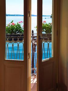 an open door to a balcony with a view of the water at Appartamenti Vistaqua in Baveno