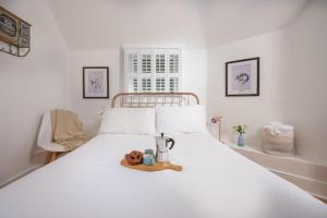 een wit bed met een dienblad met eten erop bij Mordros, St Ives in St Ives