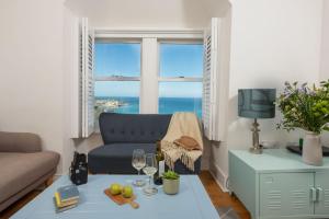 een woonkamer met een bank en een tafel met wijnglazen bij Mordros, St Ives in St Ives