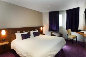 a hotel room with a large bed and a desk at Brit Hotel Tours Sud – Le Cheops in Joue-les-Tours