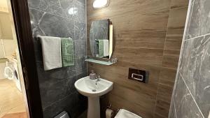 a bathroom with a sink and a toilet and a mirror at Kemer Comfort Apartment 01 in Kemer +31 photos