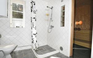 a bathroom with a shower with black and white tiles at Cozy cottage on Gotland with sauna near salty baths in Lärbro