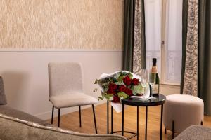 a living room with a table with a bouquet of flowers at Grand Hôtel Lévêque in Paris
