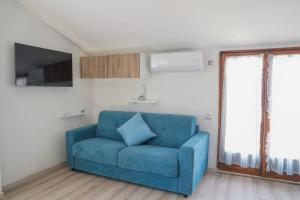 ein blaues Sofa im Wohnzimmer mit Fenstern in der Unterkunft Terrazza Marina in Torre di Montalto