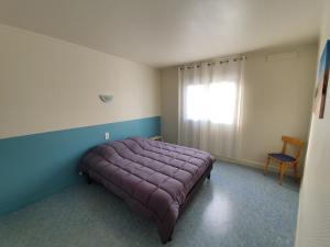 um quarto com uma cama roxa e uma janela em Les apparts de l'atlantique em La Faute-sur-Mer