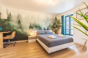 - une chambre avec un lit orné d'une peinture d'arbres sur le mur dans l'établissement Le CosyGreen - Central/Netflix/Wifi Fibre - Séjour Lozère, à Mende