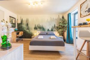 ein Schlafzimmer mit einem Bett und einem Gemälde von Bäumen an der Wand in der Unterkunft Le CosyGreen - Central/Netflix/Wifi Fibre - Séjour Lozère in Mende