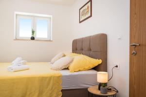 1 dormitorio con 1 cama con sábanas amarillas y ventana en Holiday home Figurica en Novigrad Dalmatia