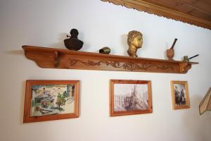 une étagère avec des photos et une statue sur un mur dans l'établissement Grandma's Home, à Gjirokastër
